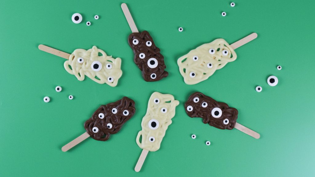 Several Halloween themed monster chocolate lollies decorated with googly eyes