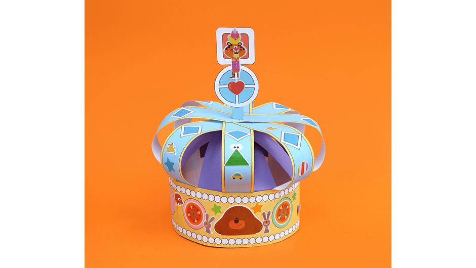 A finished hand-crafted Hey Duggee crown made from a paper template with lots of illustrations of characters from the show.
